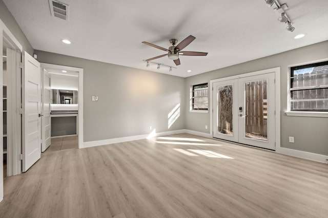 interior space with rail lighting, ceiling fan, light hardwood / wood-style floors, and french doors