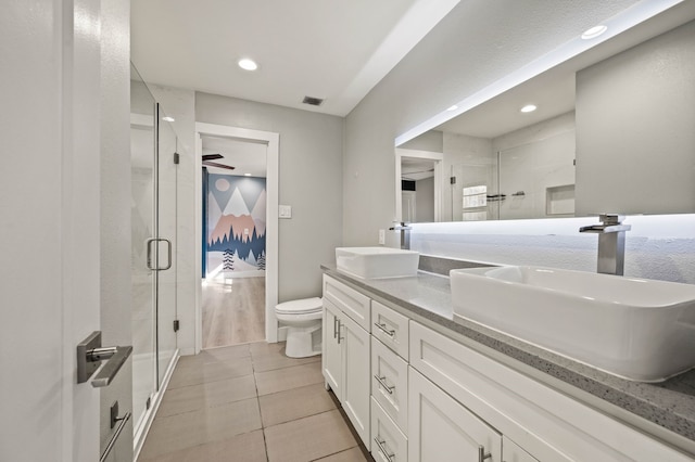 bathroom with toilet, tile patterned floors, a shower with shower door, and vanity