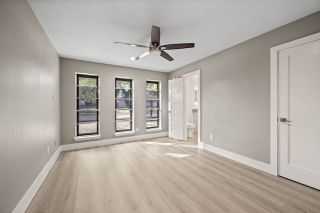 spare room with light hardwood / wood-style floors, ceiling fan, and a textured ceiling