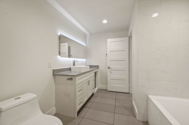 bathroom with vanity, toilet, a bath, and tile patterned floors