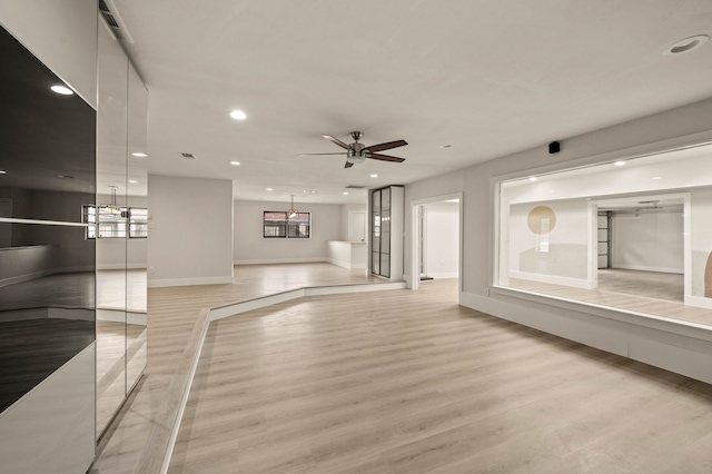 unfurnished living room featuring ceiling fan and light hardwood / wood-style flooring