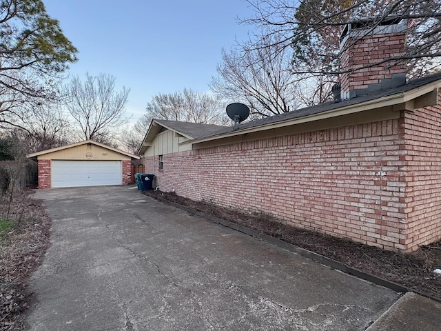 2732 Foxcroft Cir, Denton, TX 76209 - view of side of property with an outbuilding, a chimney, brick siding, a detached garage, and roof with shingles