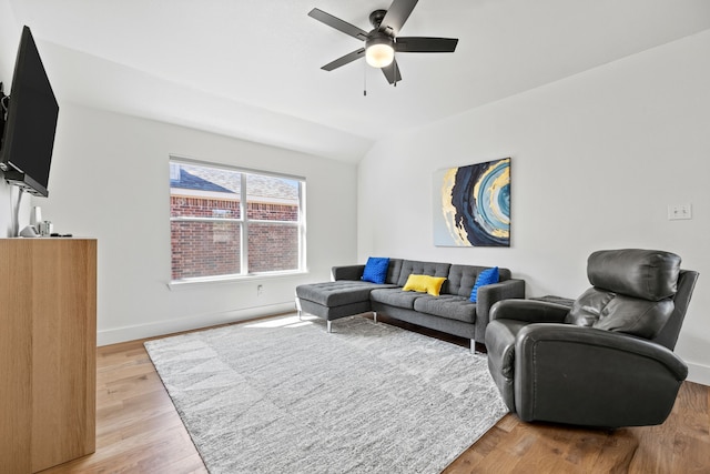 living room with ceiling fan, vaulted ceiling, and wood-type flooring