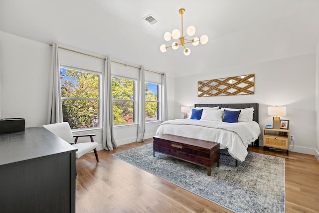 bedroom with a chandelier and wood-type flooring