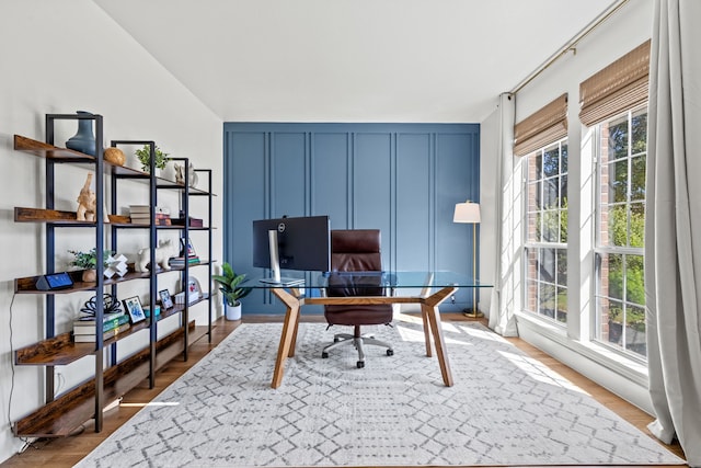 office with wood-type flooring and lofted ceiling