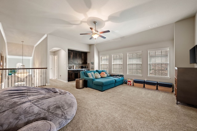 living area featuring a ceiling fan, light colored carpet, visible vents, and arched walkways