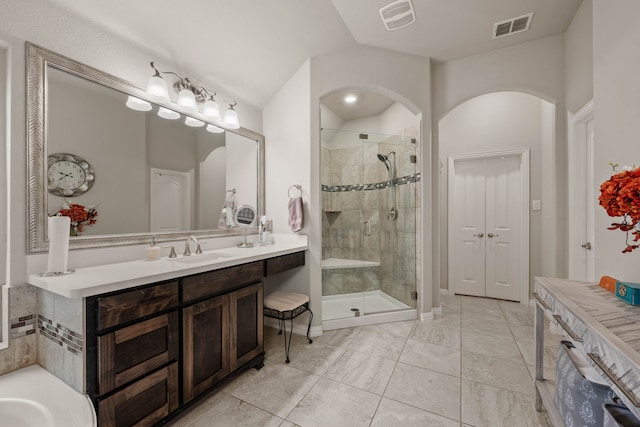 bathroom featuring vanity, a shower stall, and visible vents