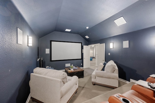 home theater room featuring baseboards, a textured wall, light colored carpet, vaulted ceiling, and a textured ceiling