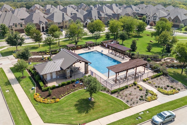 community pool with a residential view, fence, and a pergola