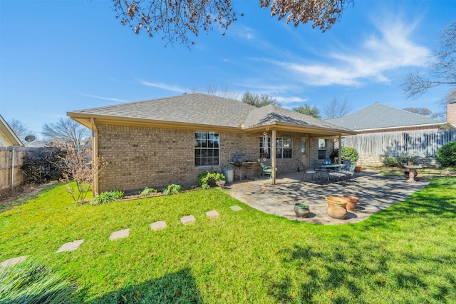 back of house featuring a lawn and a patio