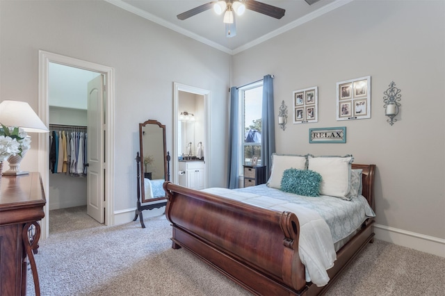 bedroom with a spacious closet, baseboards, crown molding, and light colored carpet