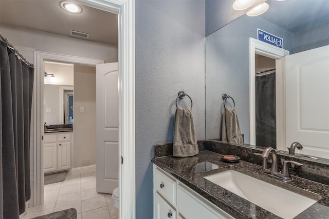 bathroom with tile patterned flooring, visible vents, vanity, and toilet