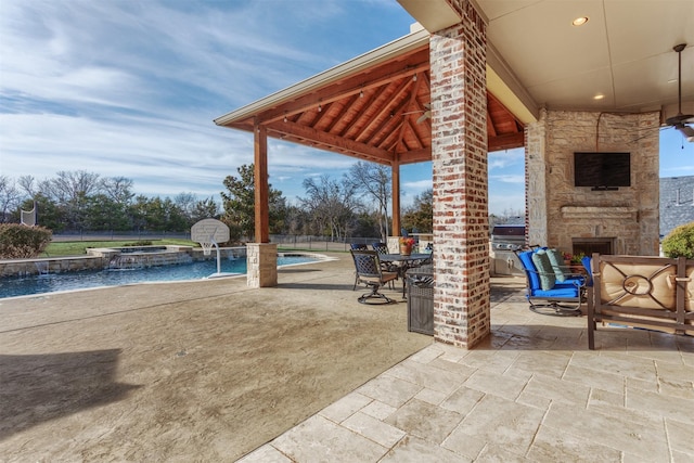 view of patio / terrace featuring a gazebo, an outdoor stone fireplace, and a pool with connected hot tub