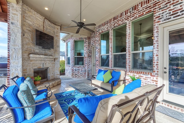 view of patio / terrace with a ceiling fan and an outdoor living space with a fireplace