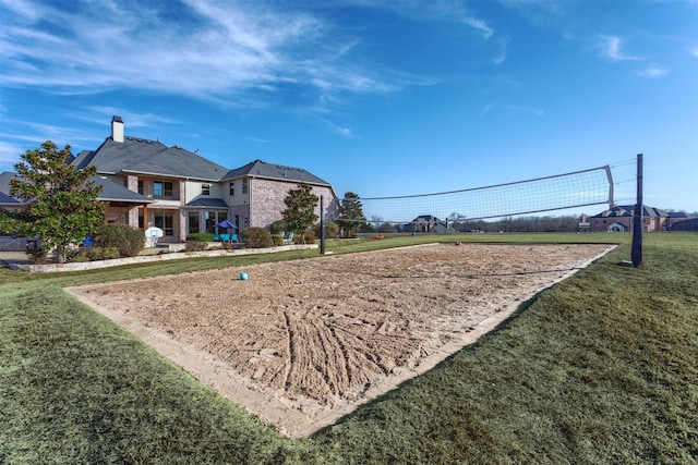 view of home's community with volleyball court and a yard