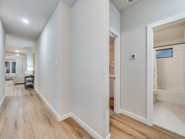 corridor with light hardwood / wood-style flooring