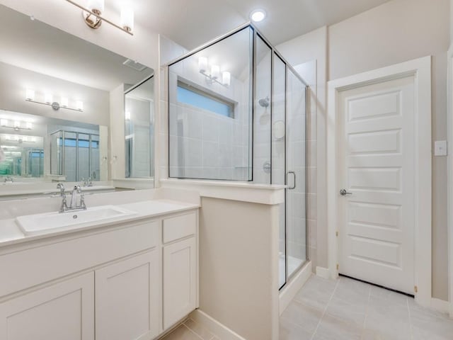 bathroom with tile patterned floors, a shower with shower door, and vanity