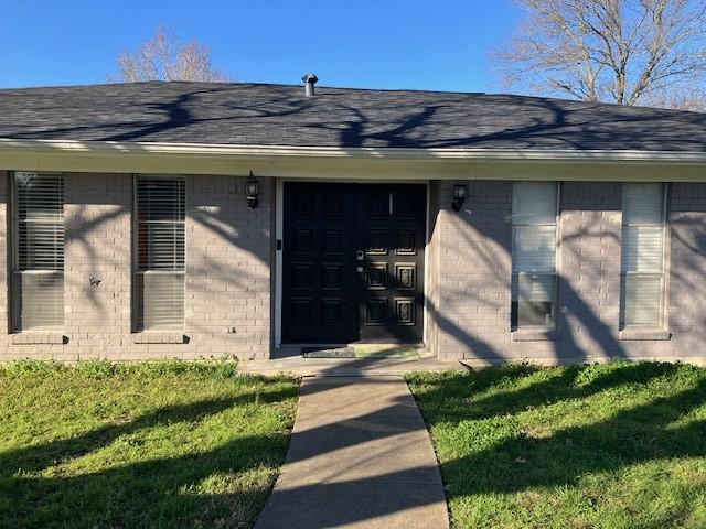 entrance to property with a lawn