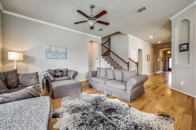 living room with light wood-type flooring, ceiling fan, and ornamental molding