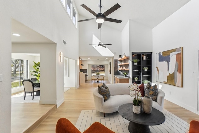 living room with ceiling fan and light hardwood / wood-style floors