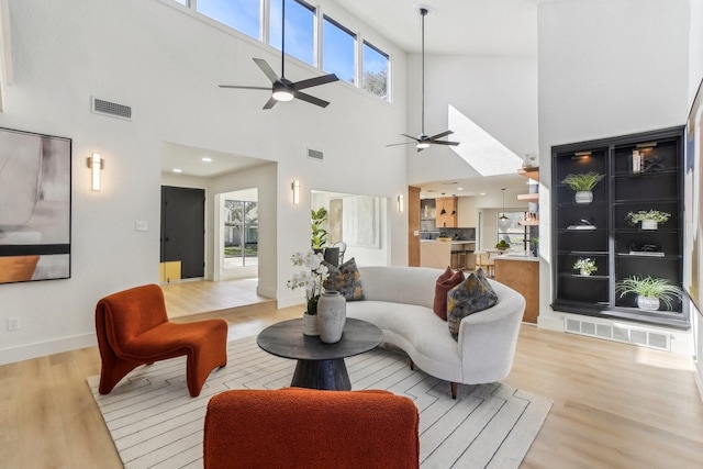 living room with ceiling fan and light hardwood / wood-style flooring