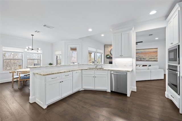 kitchen featuring dark wood finished floors, hanging light fixtures, white cabinetry, a sink, and dishwasher