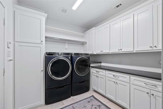 laundry room featuring light tile patterned floors, washing machine and dryer, visible vents, and cabinet space