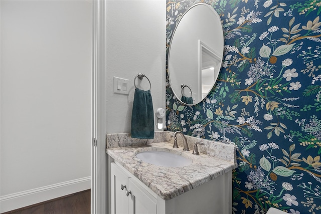 bathroom with wood finished floors, vanity, and baseboards