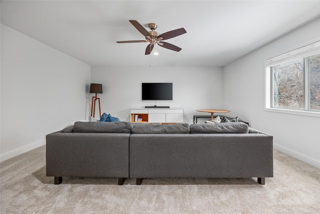 living area featuring a ceiling fan, light carpet, and baseboards