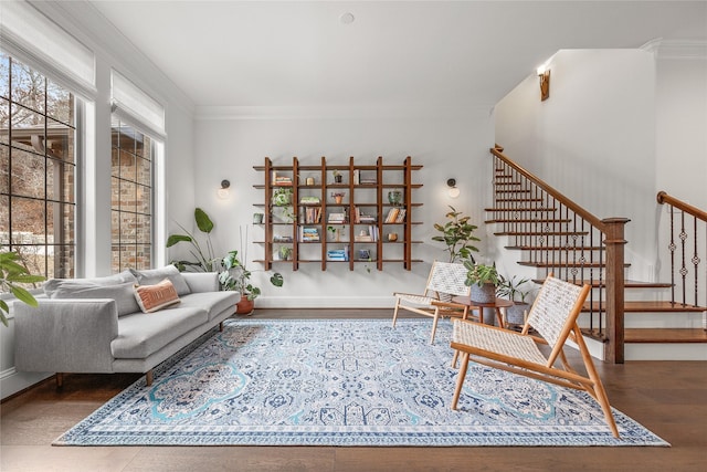 living area with ornamental molding, a wealth of natural light, stairway, and wood finished floors