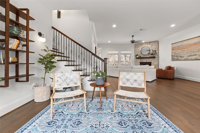 living room with baseboards, a fireplace, wood finished floors, and crown molding