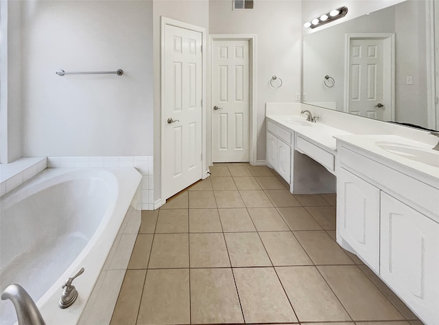 bathroom featuring tiled bath, tile patterned flooring, and vanity