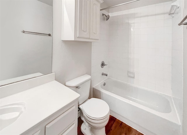 full bathroom featuring toilet, hardwood / wood-style flooring, tiled shower / bath, and vanity