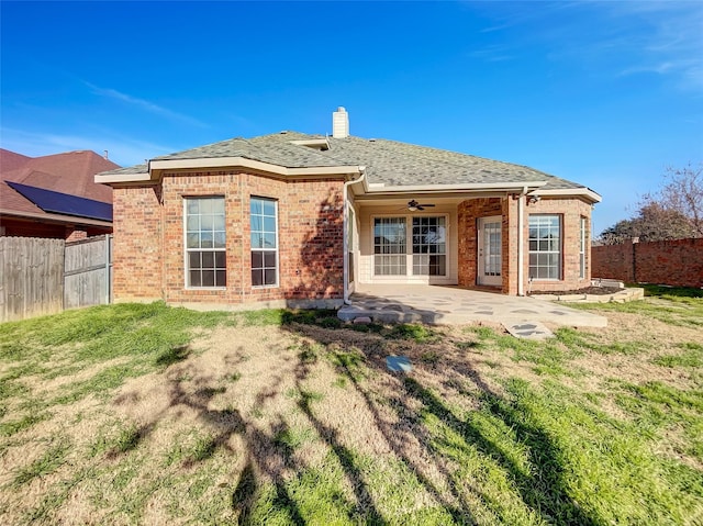 back of property with a patio, ceiling fan, and a yard