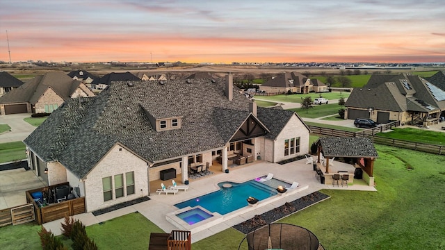 exterior space featuring an in ground hot tub, a lawn, exterior bar, and a patio area