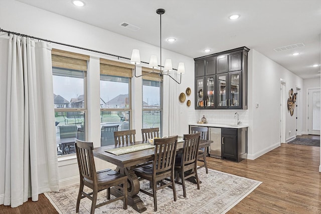 dining area with dark wood-type flooring and wet bar