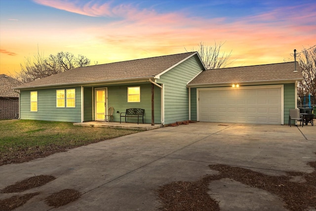 single story home with a garage and a lawn