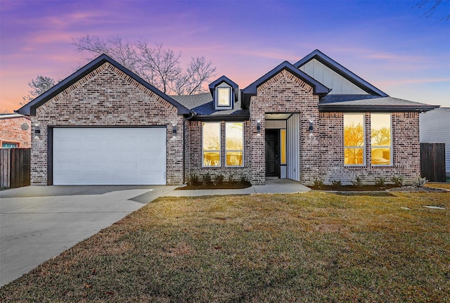 view of front of home with a garage and a lawn