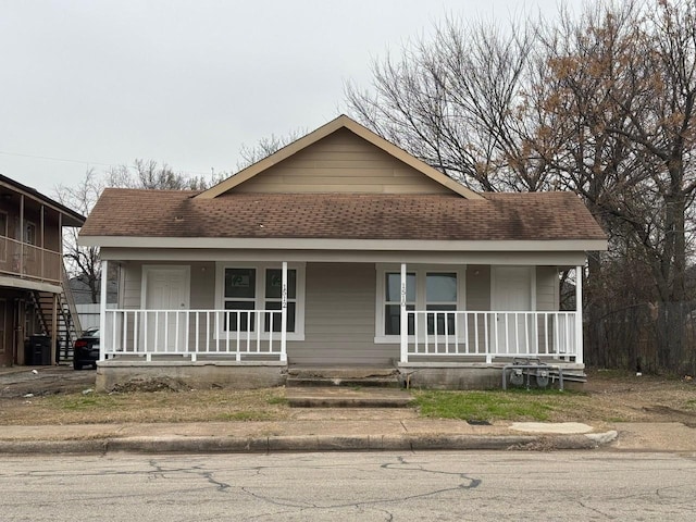 view of front facade with a porch and roof with shingles