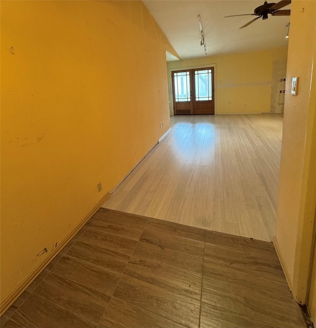 unfurnished room with hardwood / wood-style flooring, ceiling fan, and track lighting