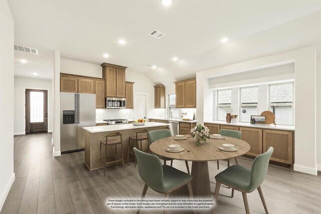 112 Woodlands Way, Balch Springs, TX 75181 - kitchen featuring stainless steel appliances, a kitchen island, plenty of natural light, brown cabinetry, and lofted ceiling