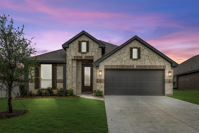 112 Woodlands Way, Balch Springs, TX 75181 - french country style house featuring stone siding, concrete driveway, roof with shingles, an attached garage, and a lawn