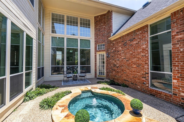 exterior space with a hot tub and a patio