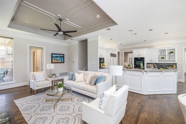 living room featuring ceiling fan, coffered ceiling, dark hardwood / wood-style flooring, ornamental molding, and sink