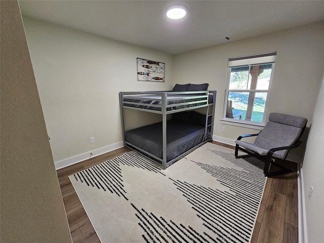 bedroom featuring wood finished floors, visible vents, and baseboards