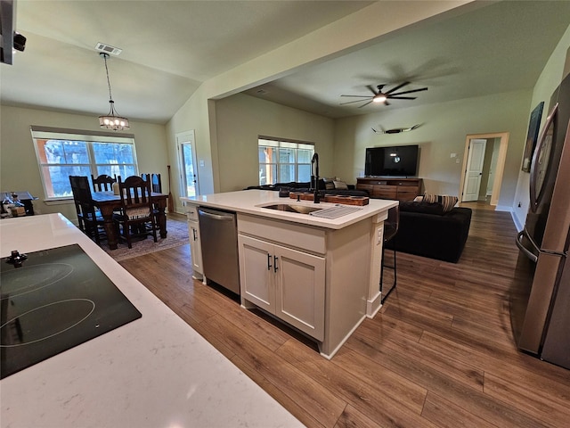 kitchen featuring stainless steel appliances, white cabinetry, light countertops, and pendant lighting