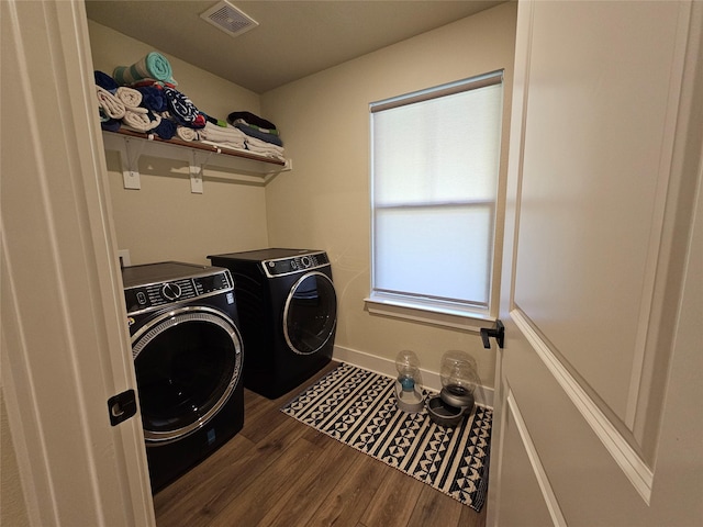 washroom with washing machine and dryer, laundry area, visible vents, baseboards, and dark wood-style floors