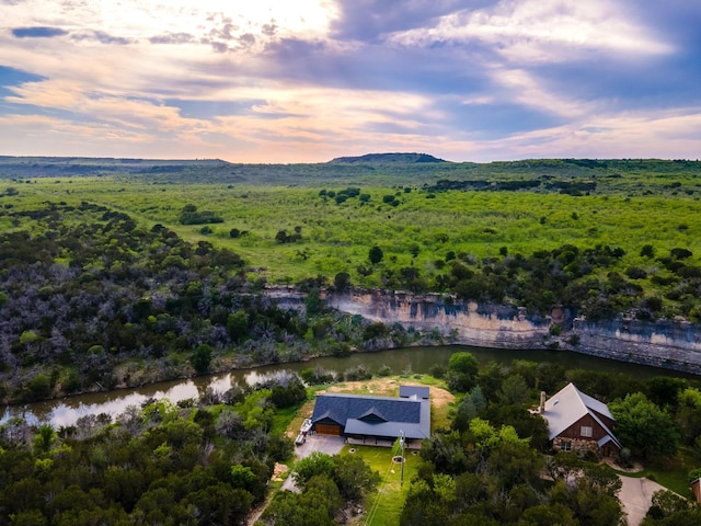 aerial view at dusk featuring a water view