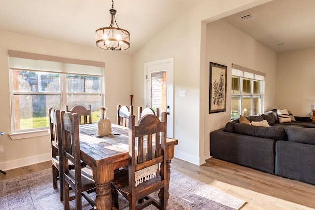 2040 Bluff Creek Dr, Strawn, TX 76475 - dining room with an inviting chandelier, light wood-style flooring, baseboards, lofted ceiling, and visible vents