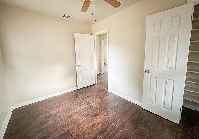 unfurnished bedroom featuring dark wood-type flooring and ceiling fan